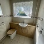 view of a commode and sink in the bathroom