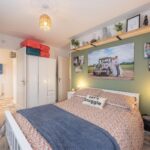 a bedroom with multiple photos on the wall
