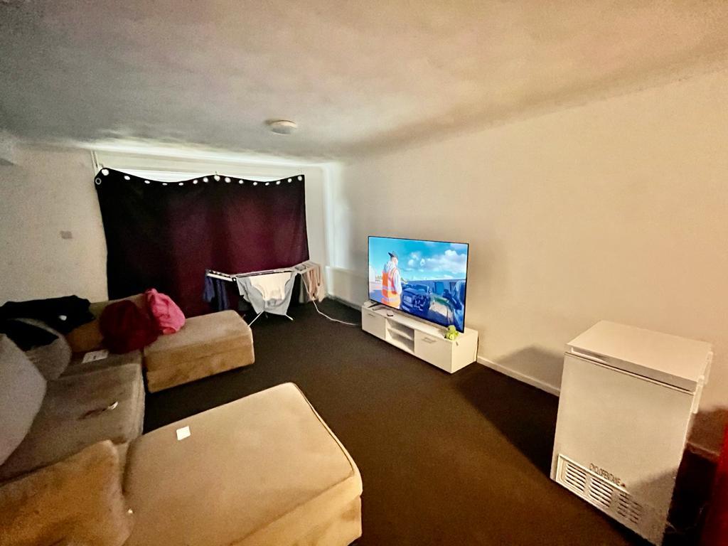 a room with sofas and a LED TV