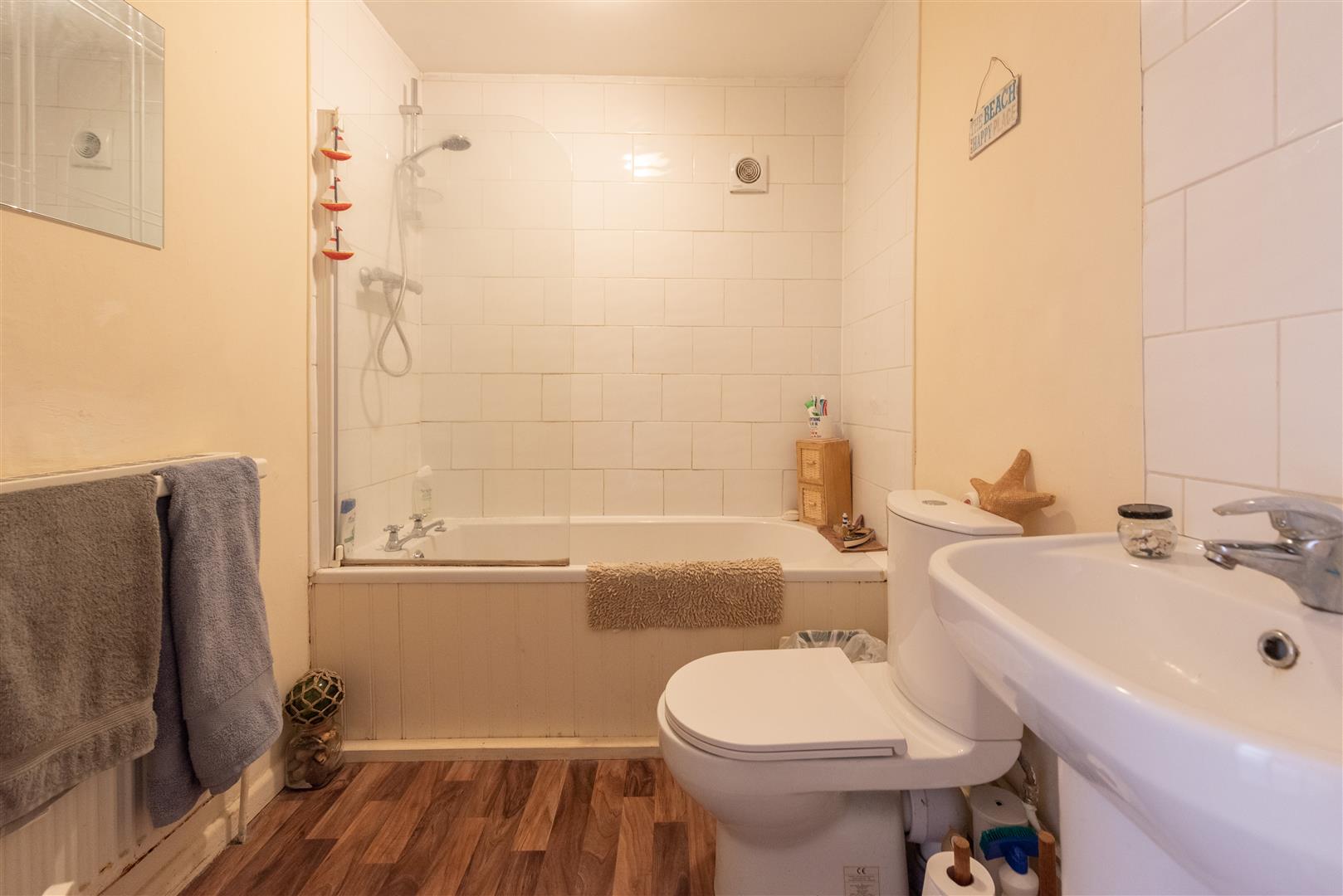 a bathroom with a bath tub, commode, and sink